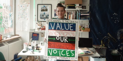 Artist Rtiiika holding up her artwork for Cabot Conversations